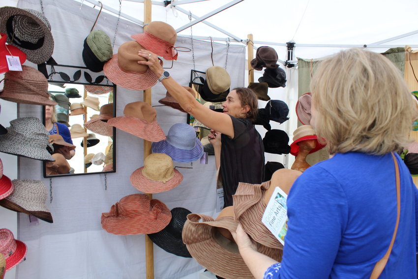 Frisco-based fiber artist Diane Harty, center, helps pick out a hat for customer Tami Rauer, right, during the Golden Fine Arts Festival Aug. 20 in downtown Golden.